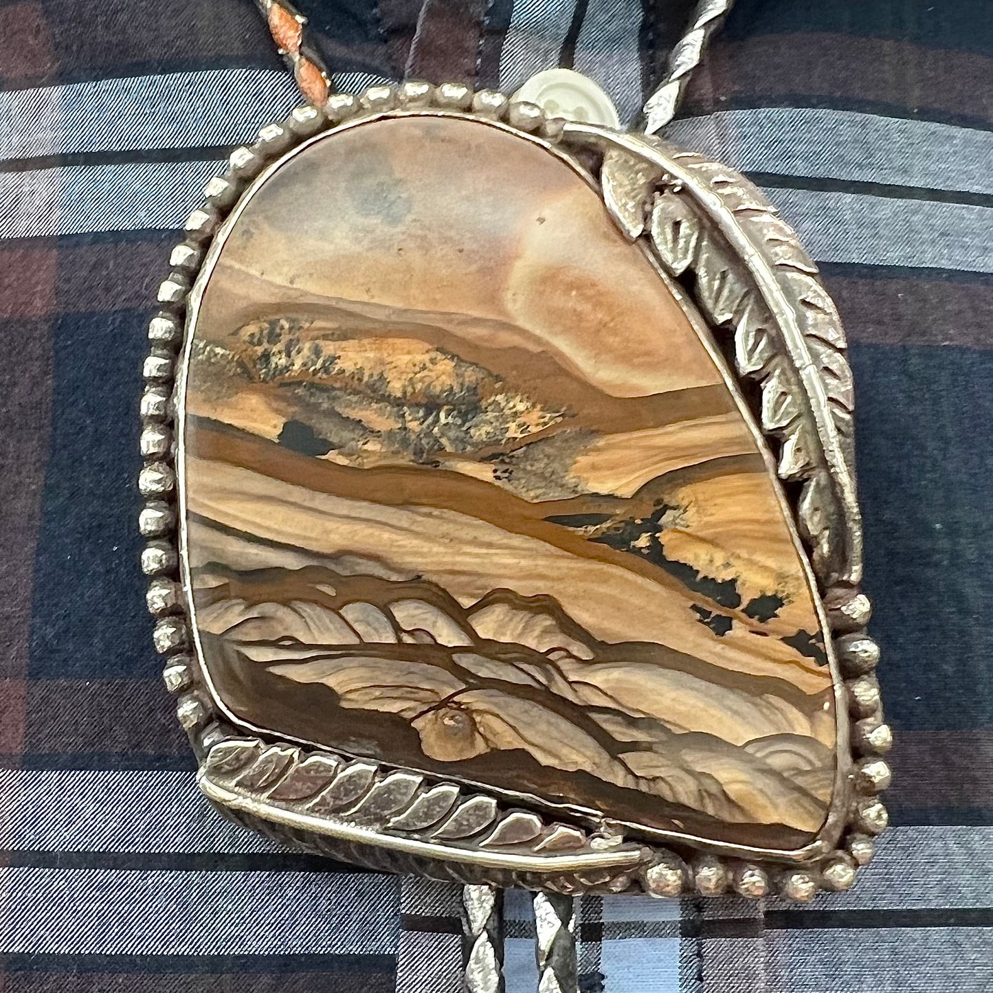 A men's sterling silver bolo tie set with a Biggs picture jasper stone.