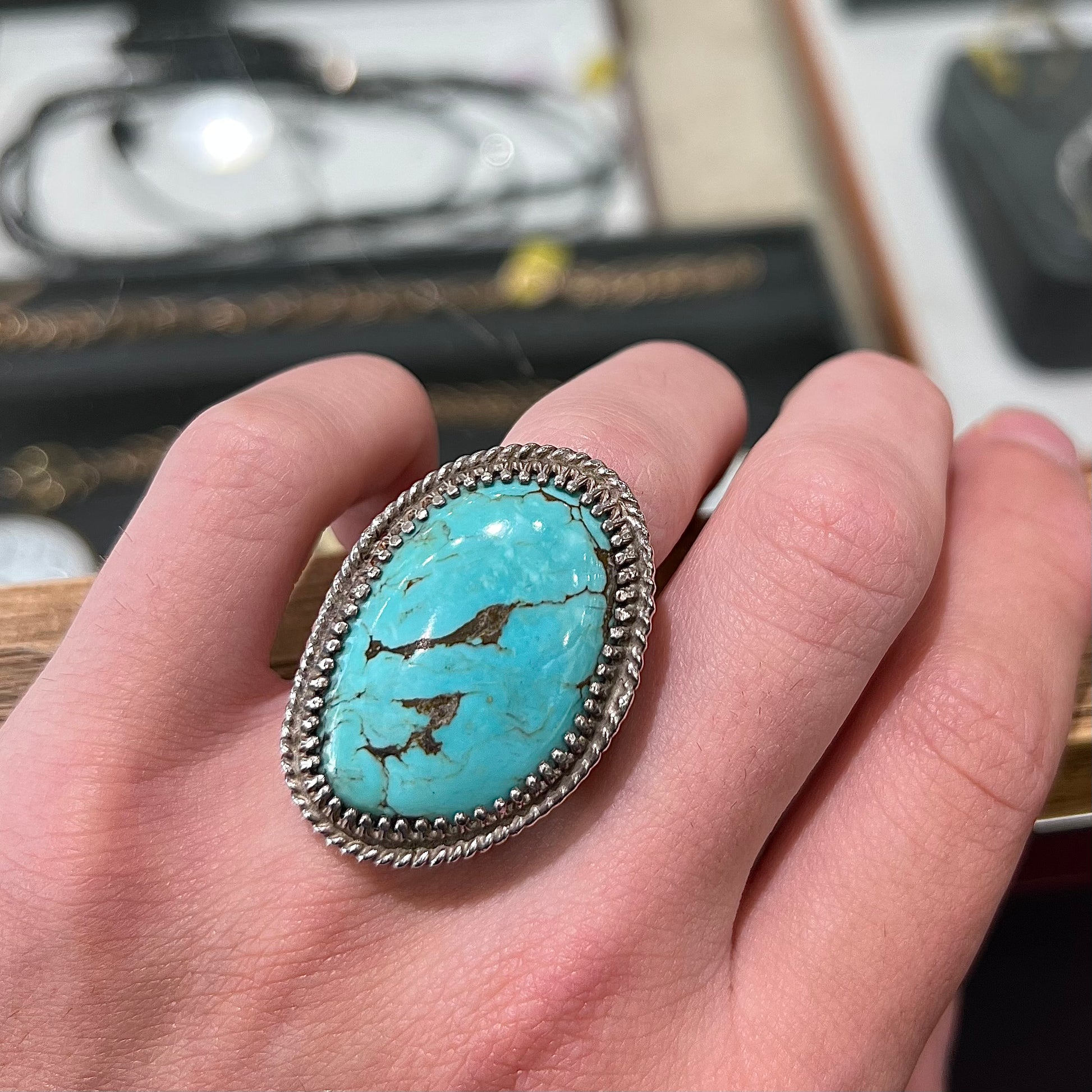 A sterling silver rope design ring set with a turquoise stone from Pilot Mountain Mine, Nevada.