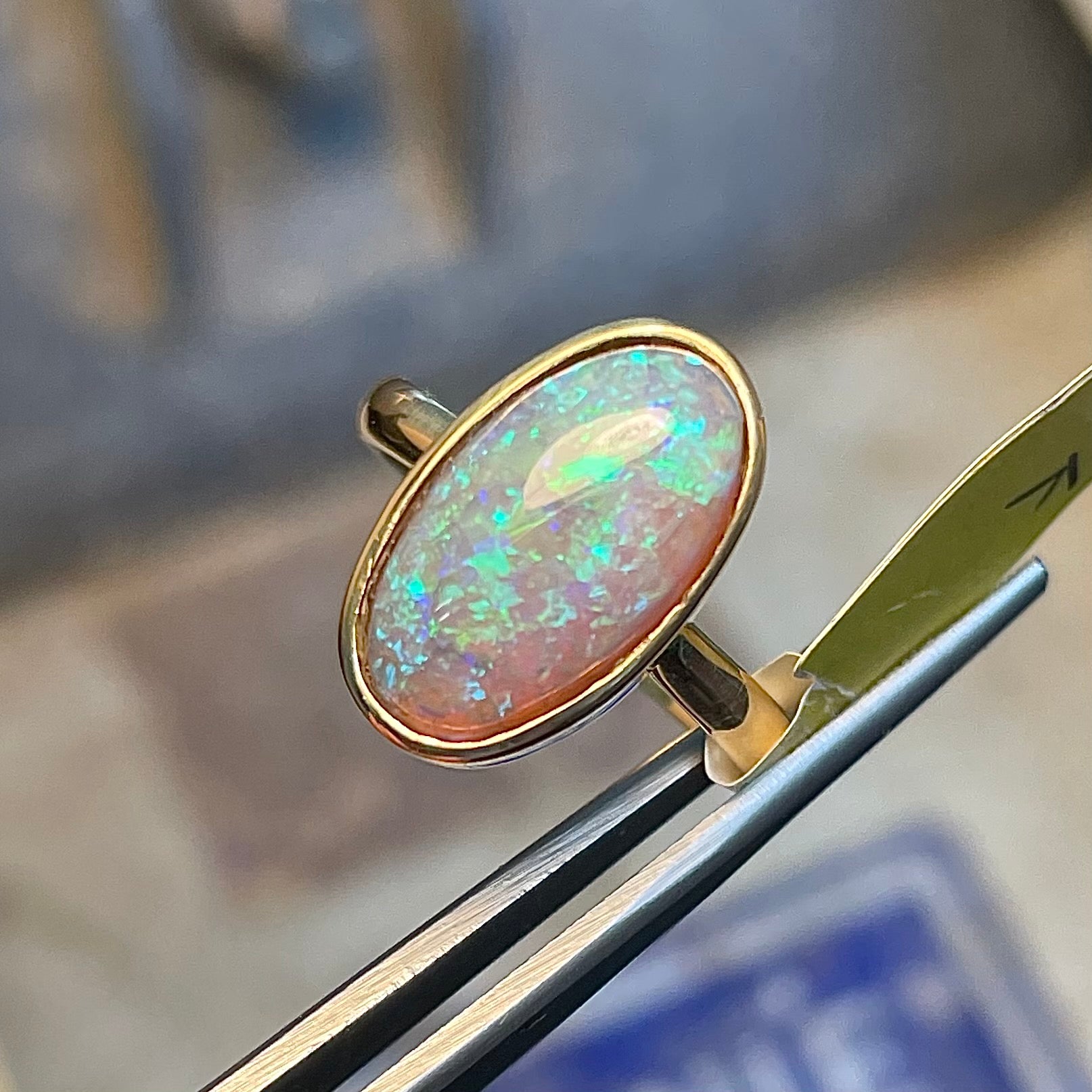A simple yellow gold solitaire ring with a bezel set Lightning Ridge black crystal opal from Australia.