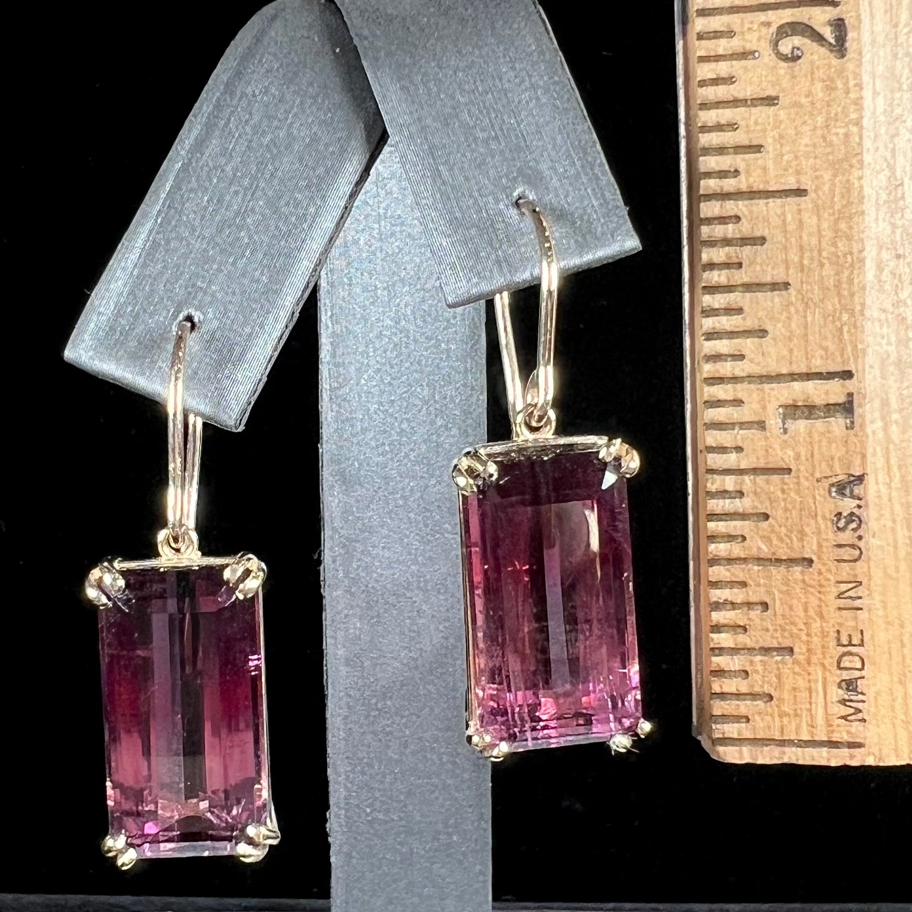 A pair of pink and magenta bicolor tourmaline dangle earrings handmade in 14kt yellow gold with basket settings and shepherd's hooks.