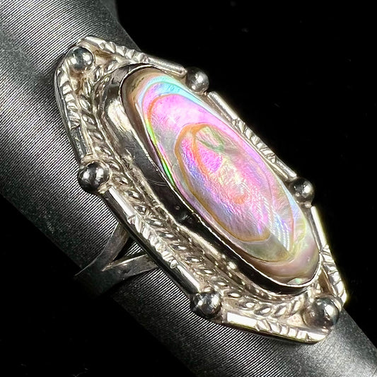 A Southwest style sterling silver ring set with a pink, oval cabochon cut mother of pearl shell.