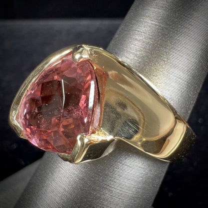 A unisex, yellow gold, trillion cut pink tourmaline solitaire ring.