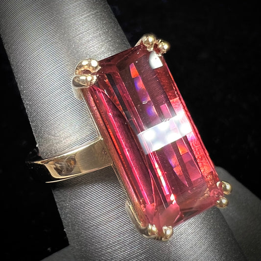 A handmade yellow gold solitaire ring set with a 7.91ct pinkish purple pixel cut tourmaline stone.