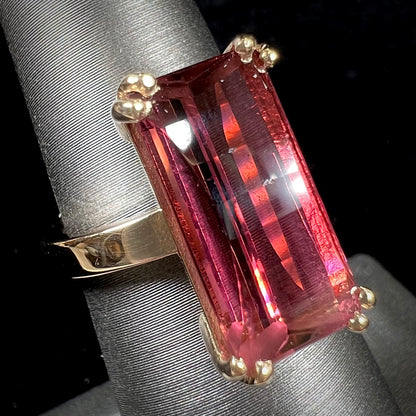 A handmade yellow gold solitaire ring set with a 7.91ct pinkish purple pixel cut tourmaline stone.