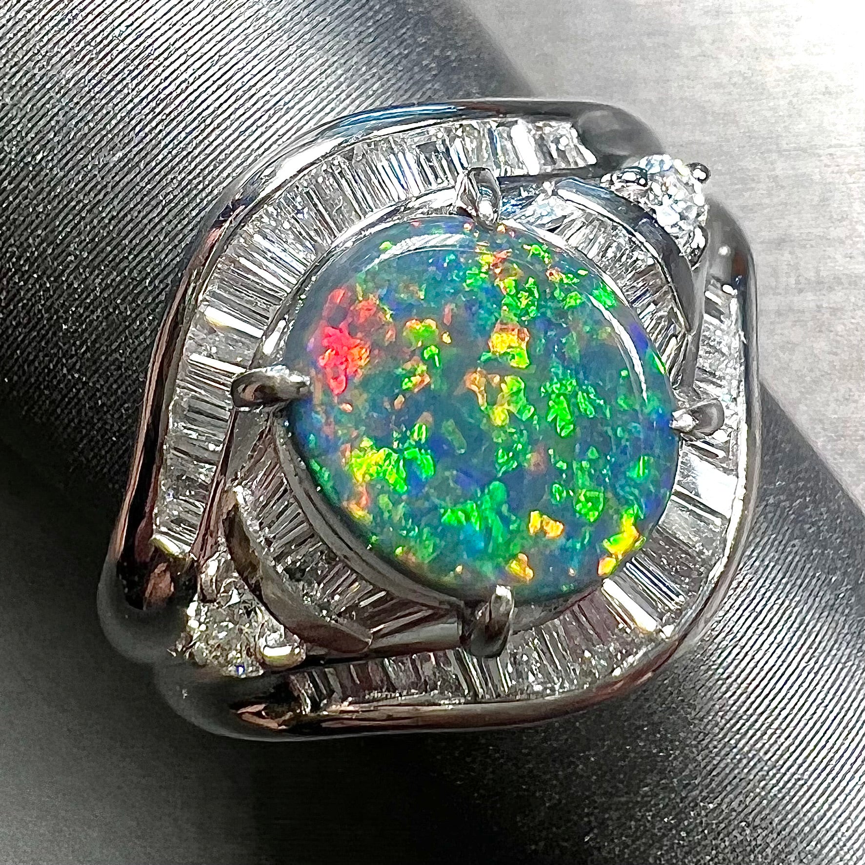 A platinum Lightning Ridge black opal ring set with baguette cut diamonds.  The opal is an oval cabochon cut.