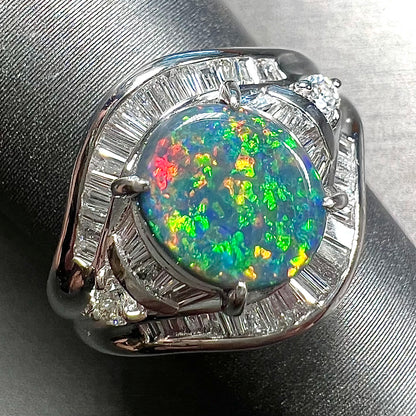 A platinum Lightning Ridge black opal ring set with baguette cut diamonds.  The opal is an oval cabochon cut.