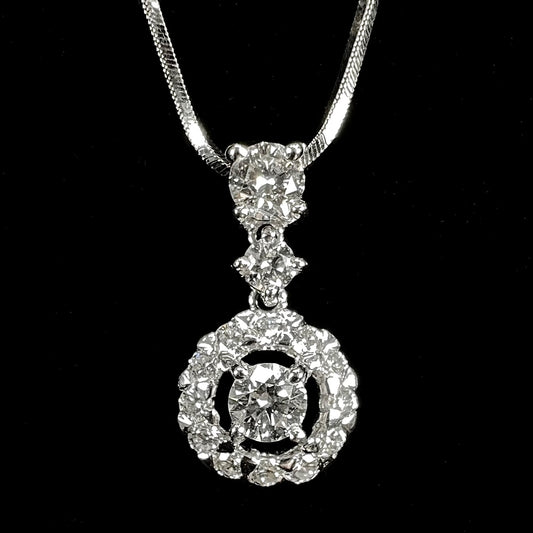A ladies' diamond halo necklace with snake chain cast in platinum.