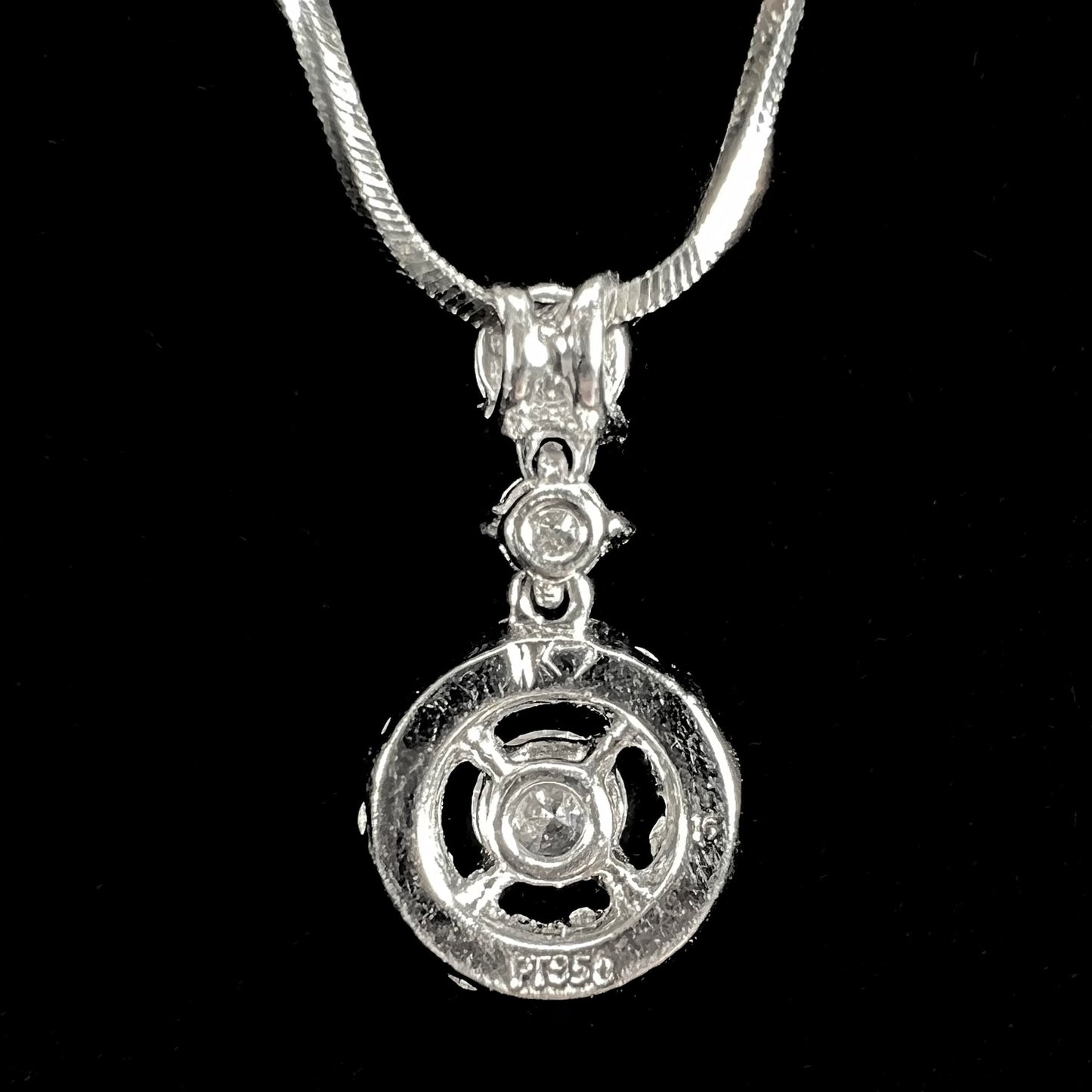 A ladies' diamond halo necklace with snake chain cast in platinum.