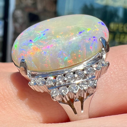 An oval cabochon cut Coober Pedy, Australian opal prong set in a platinum ring with round cut diamonds.