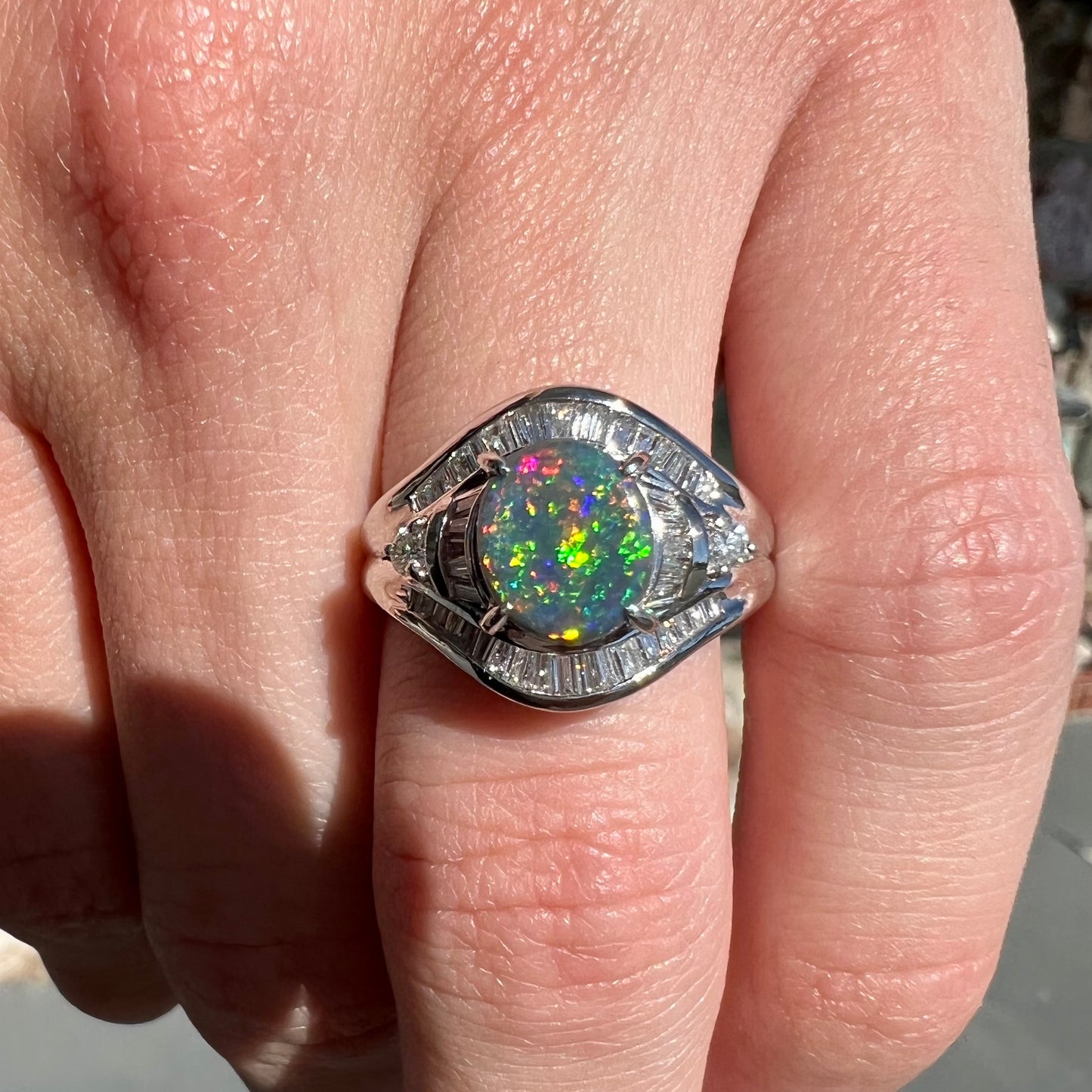 A platinum Lightning Ridge black opal ring set with baguette cut diamonds.  The opal is an oval cabochon cut.