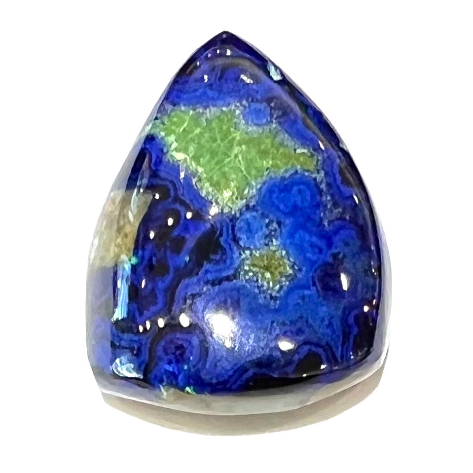 A loose pear shape cabochon cut blue azurite stone with green pseudomalachite inclusions.