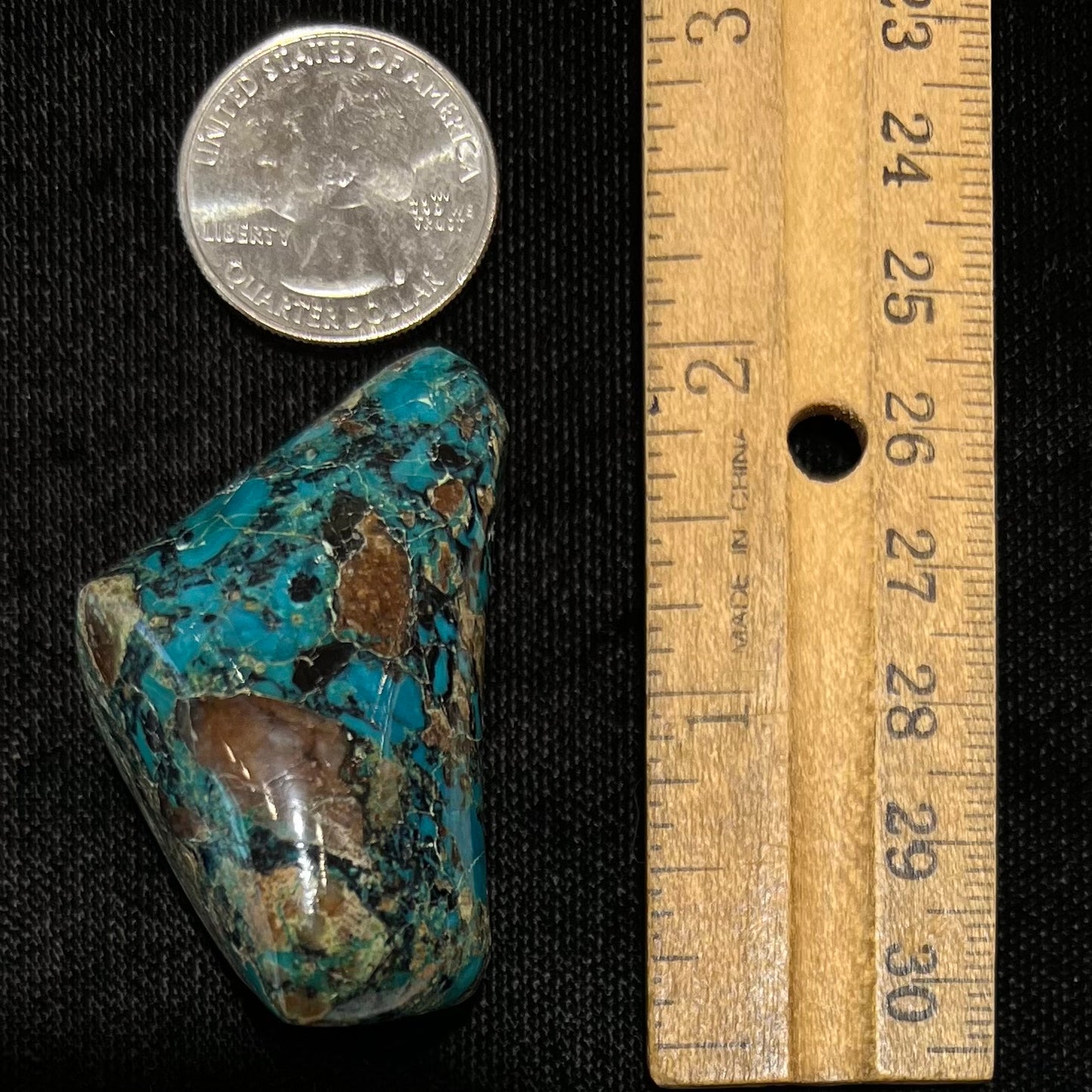 A loose polished chrysocolla stone with malachite inclusions.