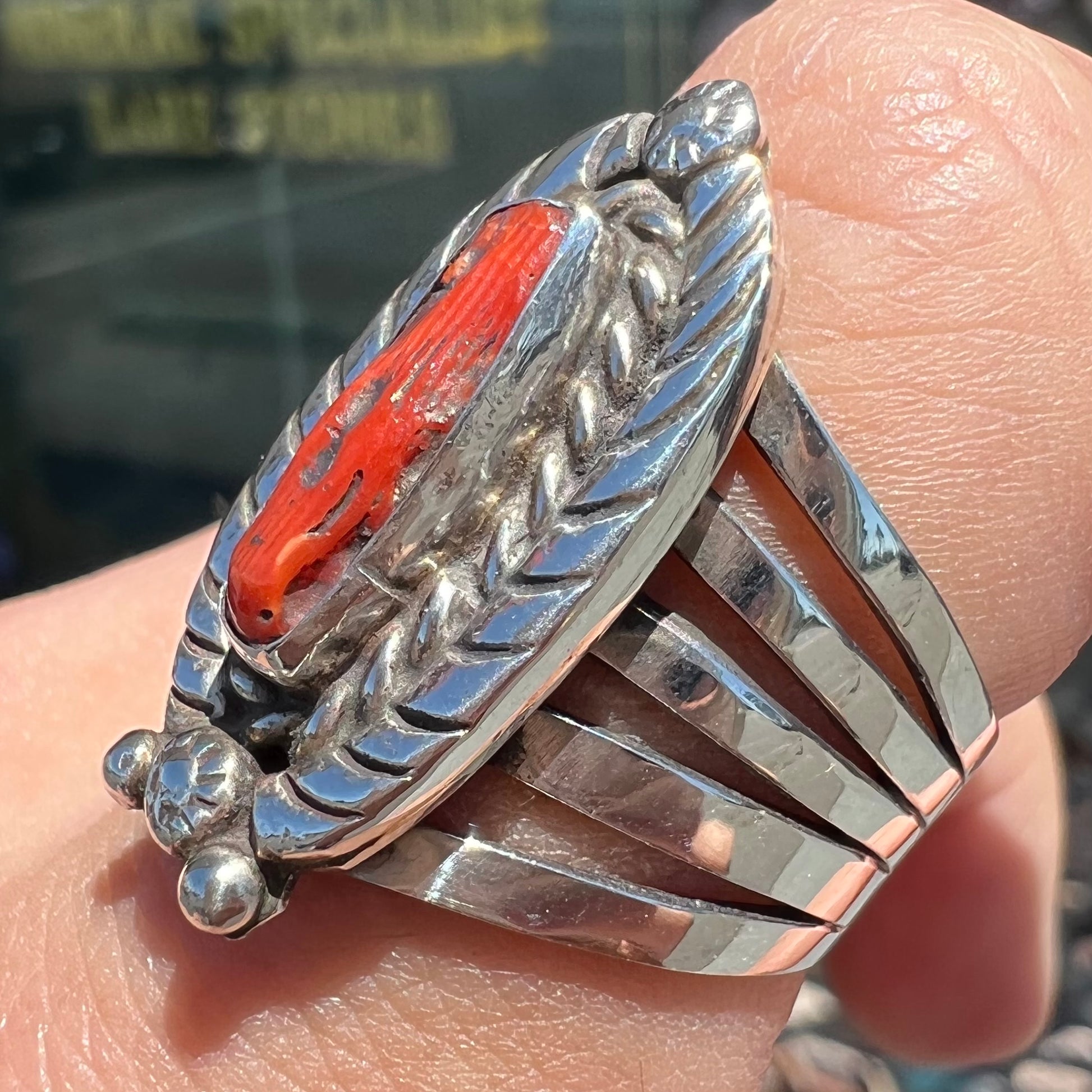 A sterling silver ring set with a polished red coral branch handmade by Navajo artist, Delbert Chatter.