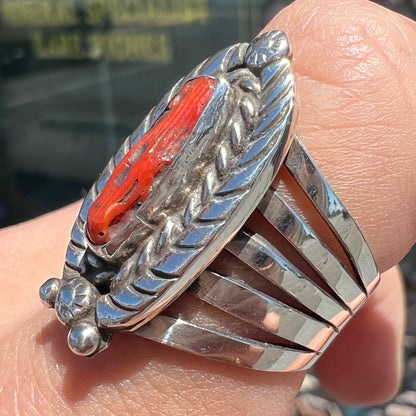 A sterling silver ring set with a polished red coral branch handmade by Navajo artist, Delbert Chatter.