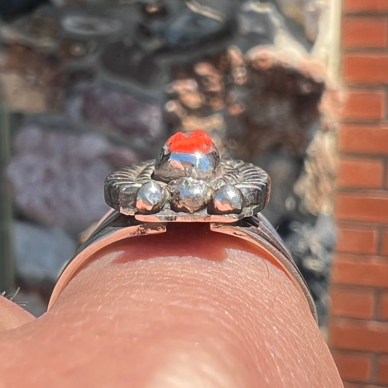 A sterling silver ring set with a polished red coral branch handmade by Navajo artist, Delbert Chatter.