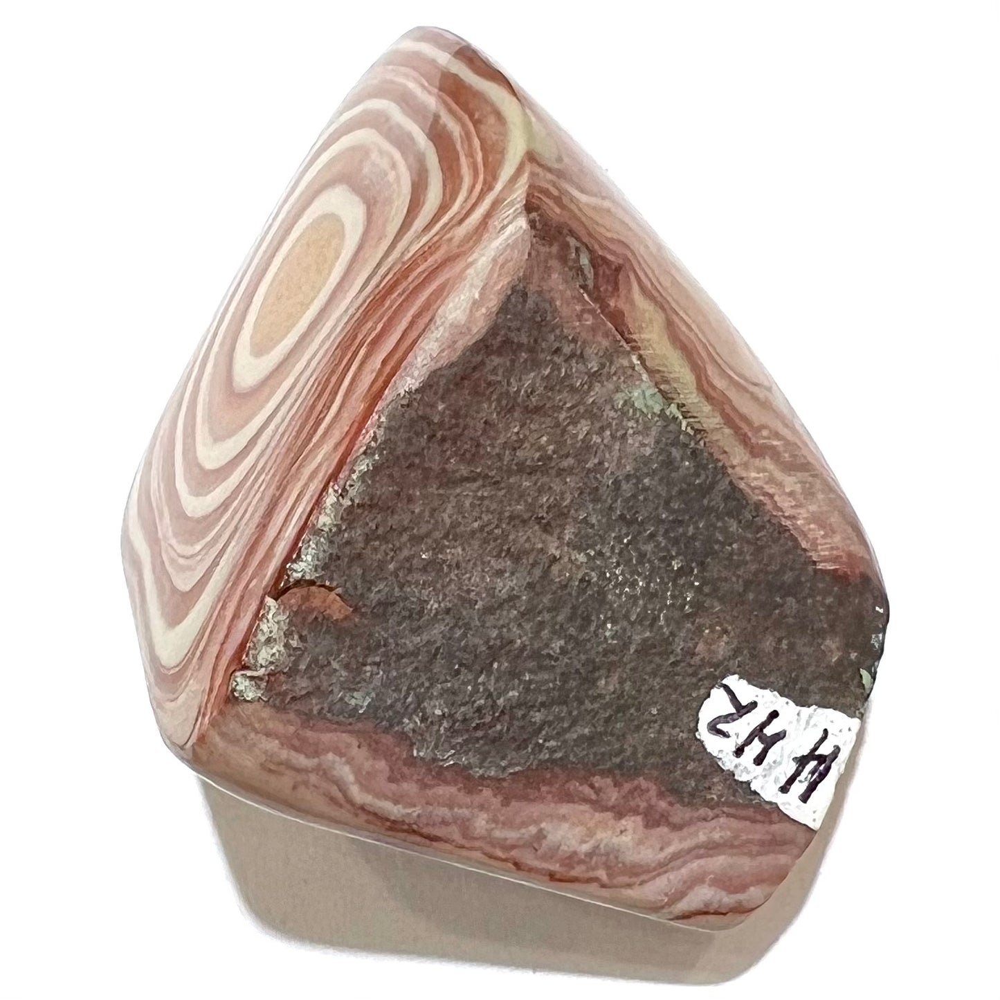 A polished piece of pinkish red picture jasper.  The stone displays a bull's eye pattern.