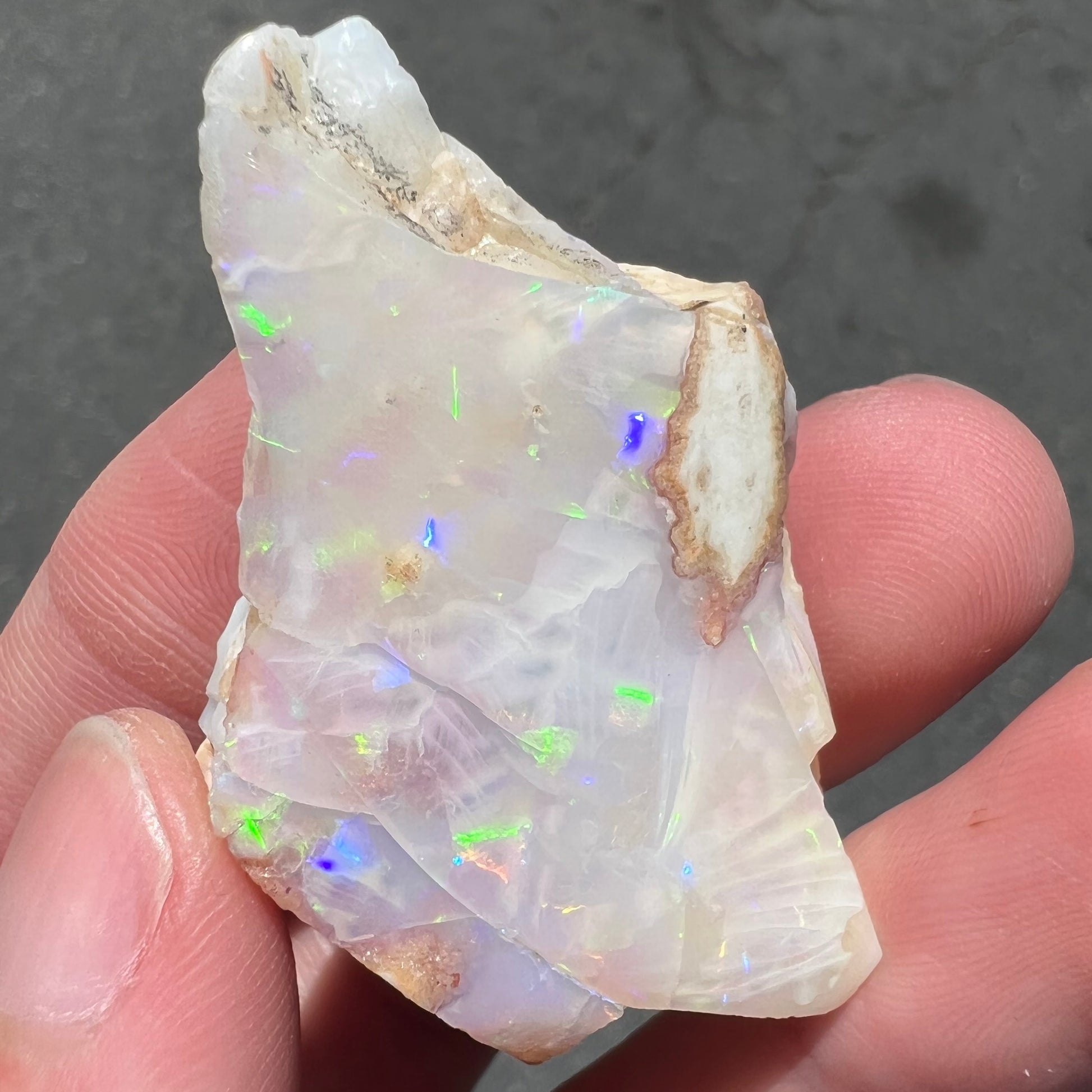 A loose, polished specimen of white crystal opal from Spencer, Idaho, USA.