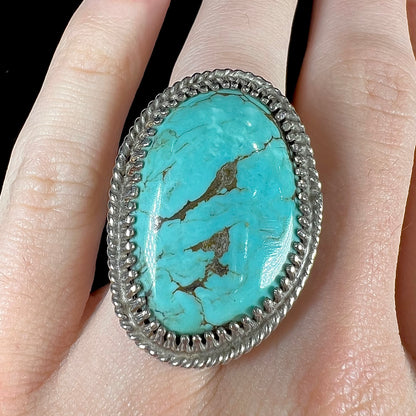 A sterling silver rope design ring set with a turquoise stone from Pilot Mountain Mine, Nevada.
