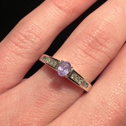 A ladies' white gold and diamond ring set with a 0.26ct alexandrite center stone that changes from green blue to lilac purple.