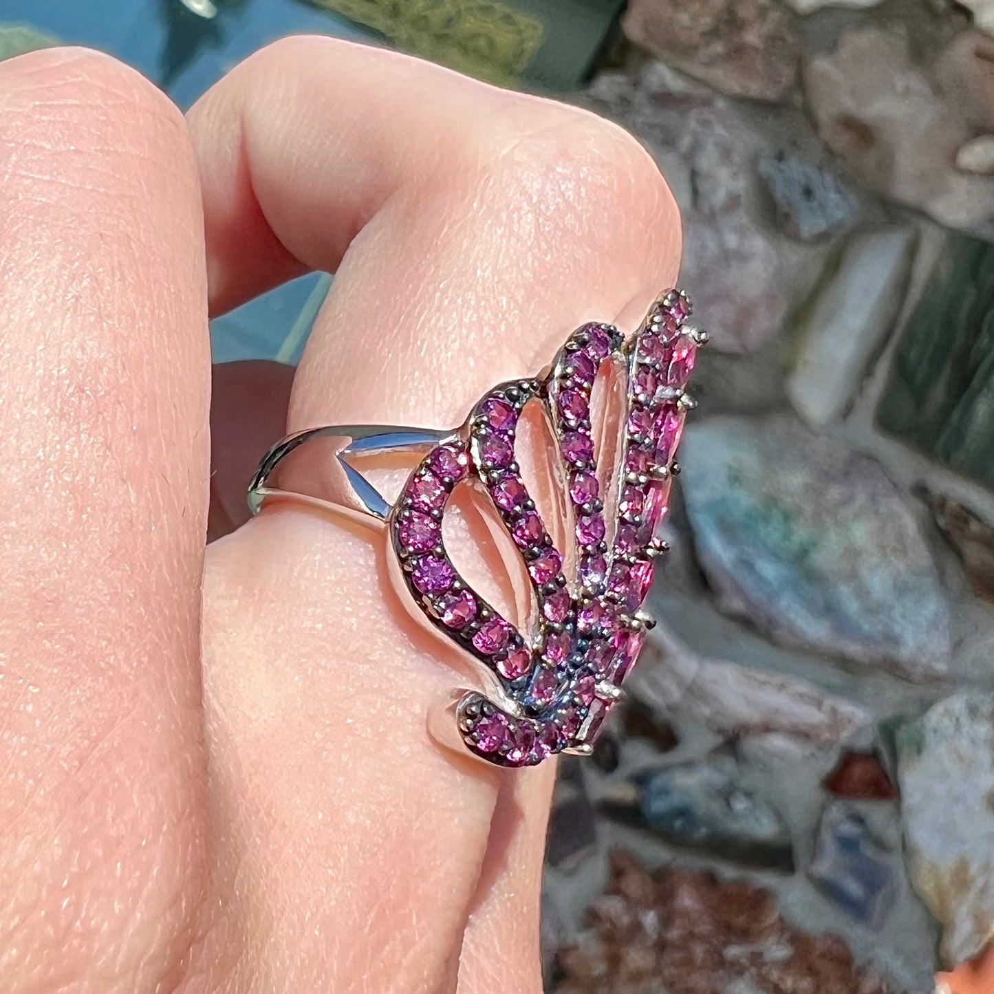 A sterling silver, feather shaped ring set with round and marquise cut rhodolite garnet stones.