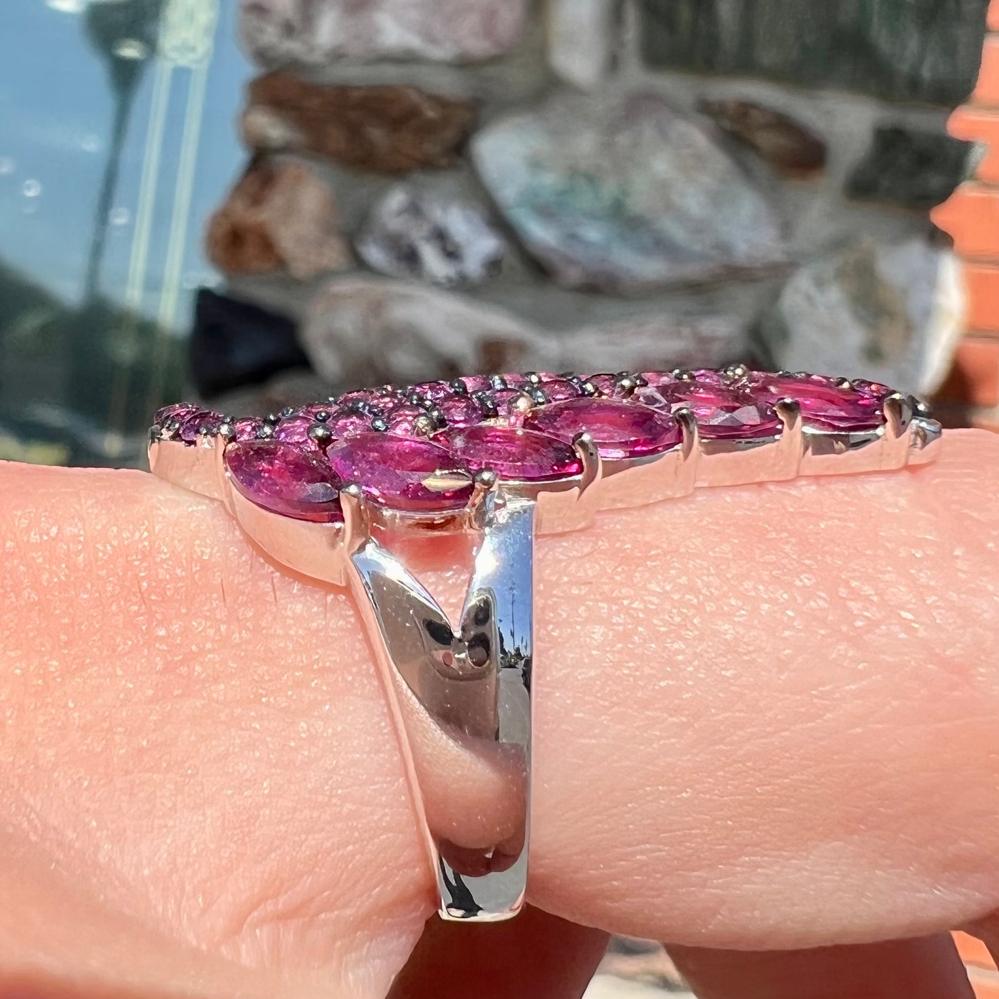 A sterling silver, feather shaped ring set with round and marquise cut rhodolite garnet stones.