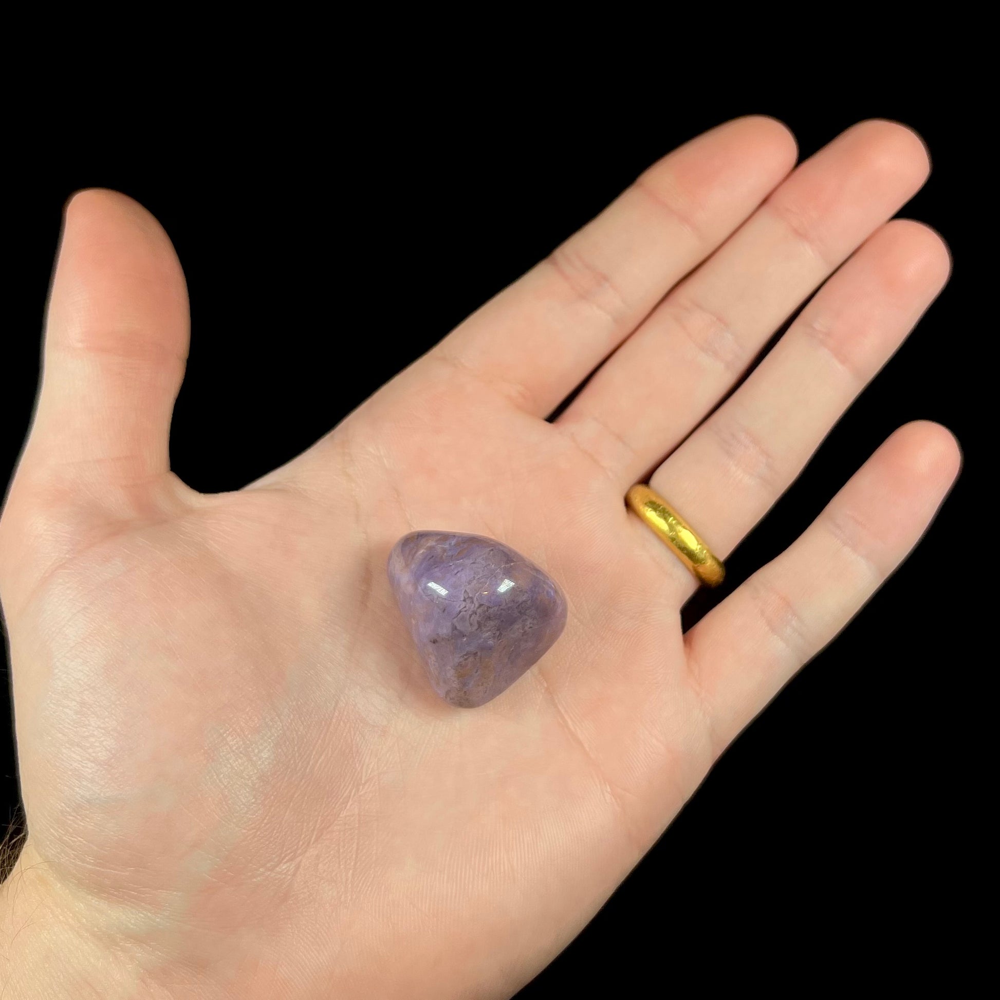 A tumbled turkiyenite stone, commonly referred to as "Turkish purple jade."