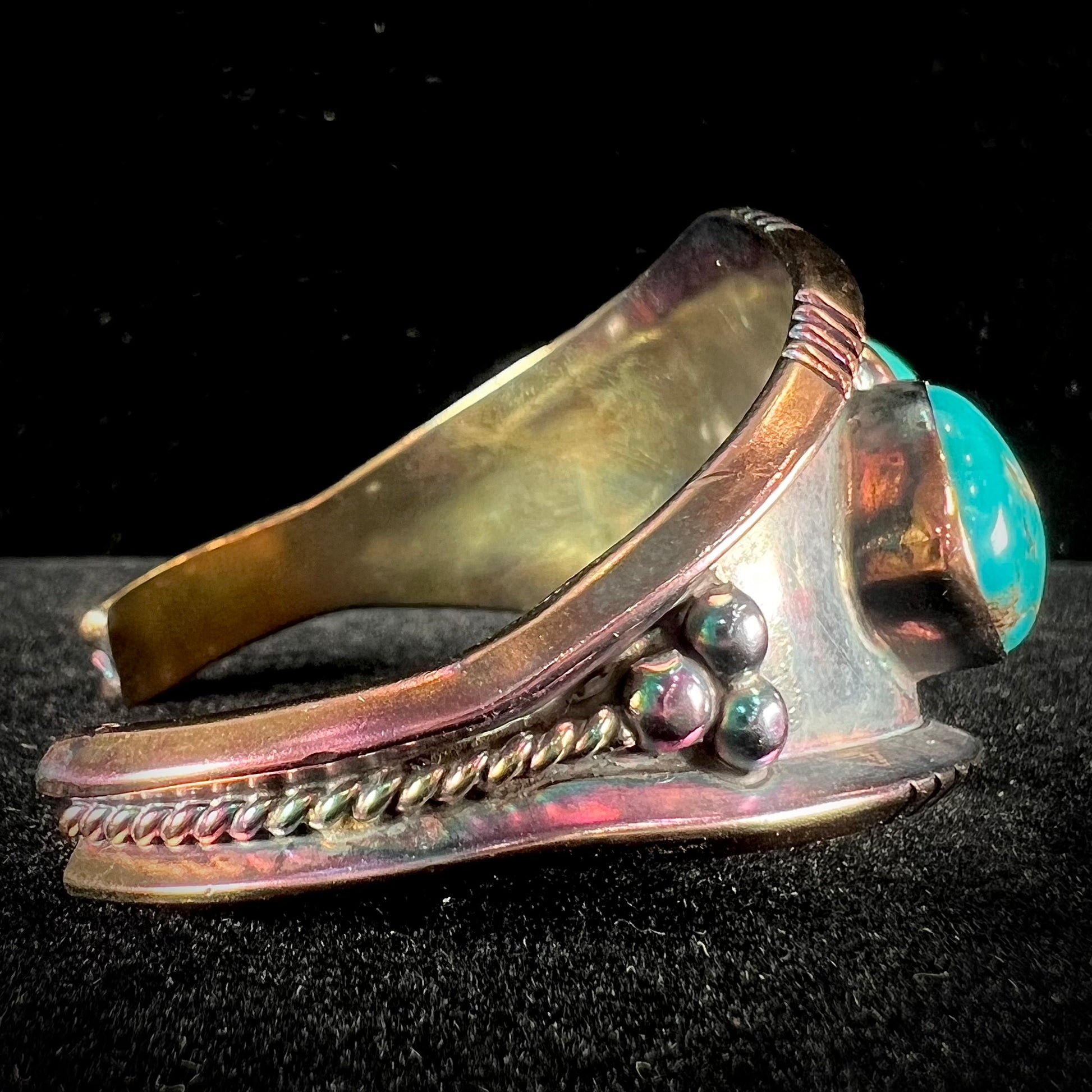 A men's Navajo three stone turquoise cuff bracelet handmade by artist, Dean Brown.  The silver has an iridescent purple patina.