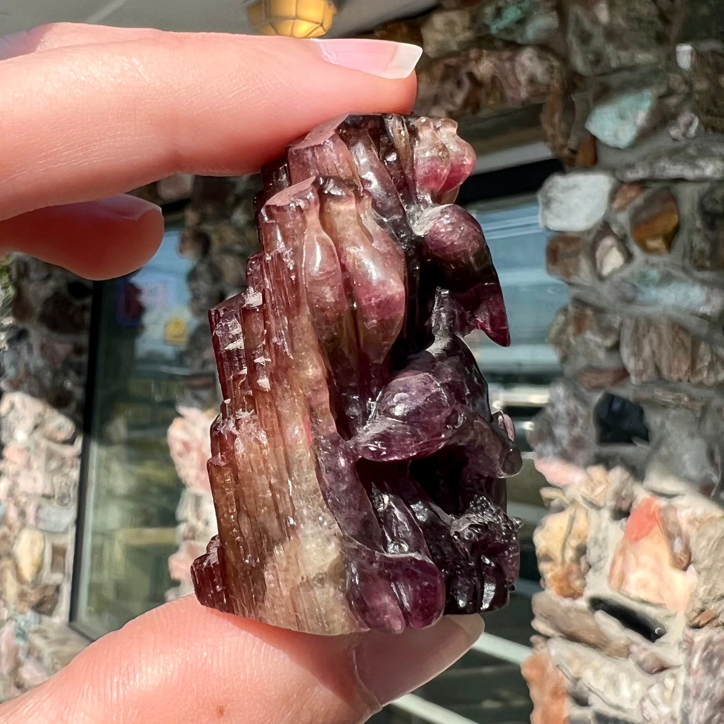 A scene of two dolphins and a starfish carved by artist, Ronald Stevens, from liddicoatite tourmaline crystal.