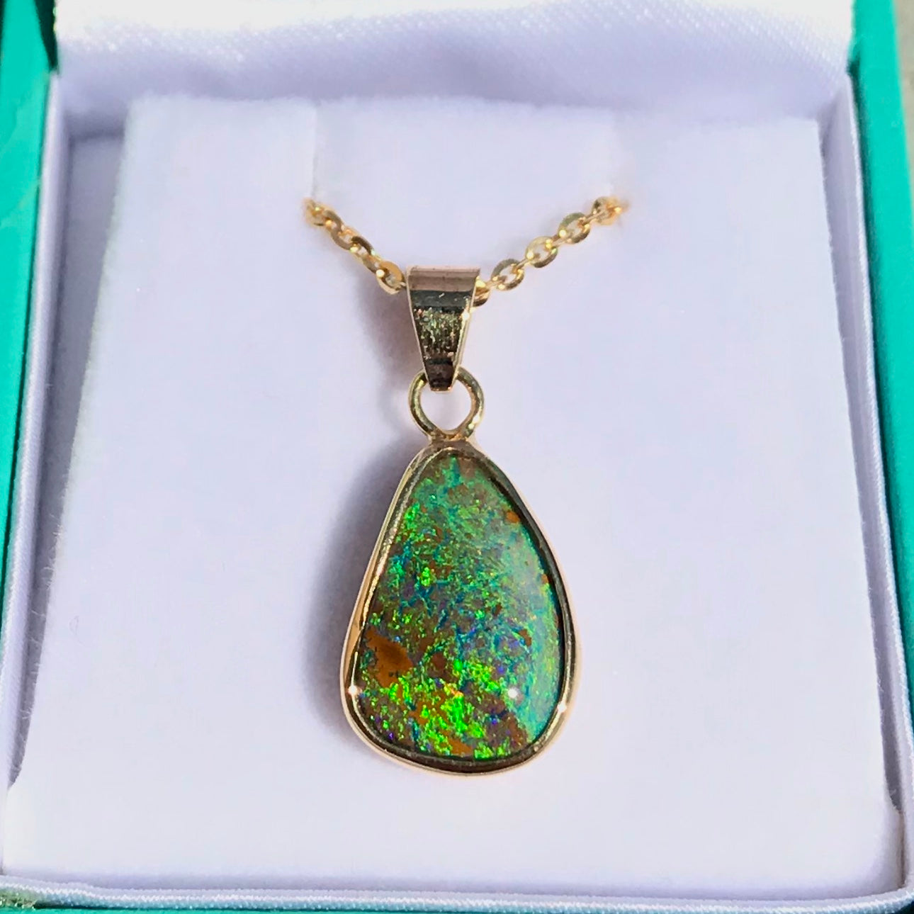 Green and blue Queensland boulder opal pendant in 14k yellow gold on cable chain.