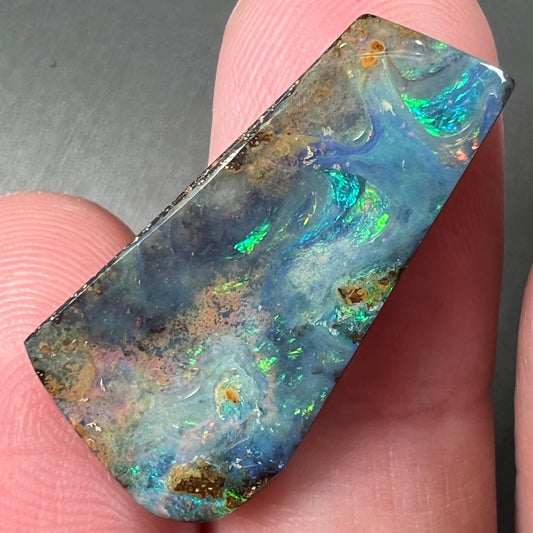 A loose, freeform cut boulder opal stone from Quilpie, Australia.