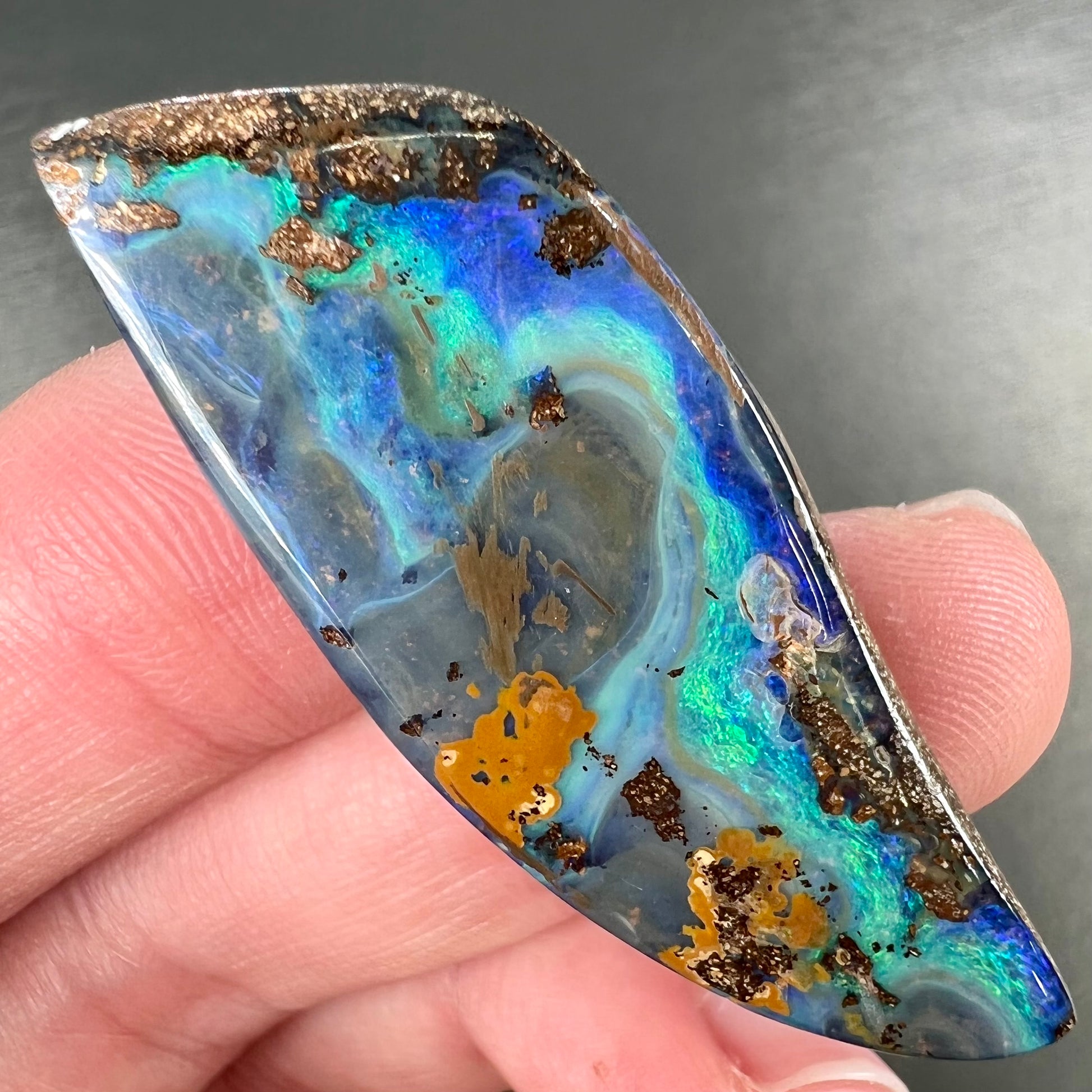 A freeform cut, loose black boulder opal stone from Queensland, Australia.