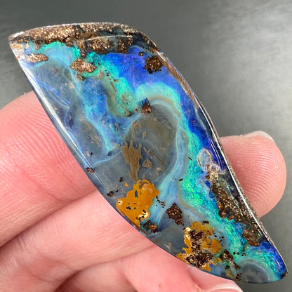 A freeform cut, loose black boulder opal stone from Queensland, Australia.