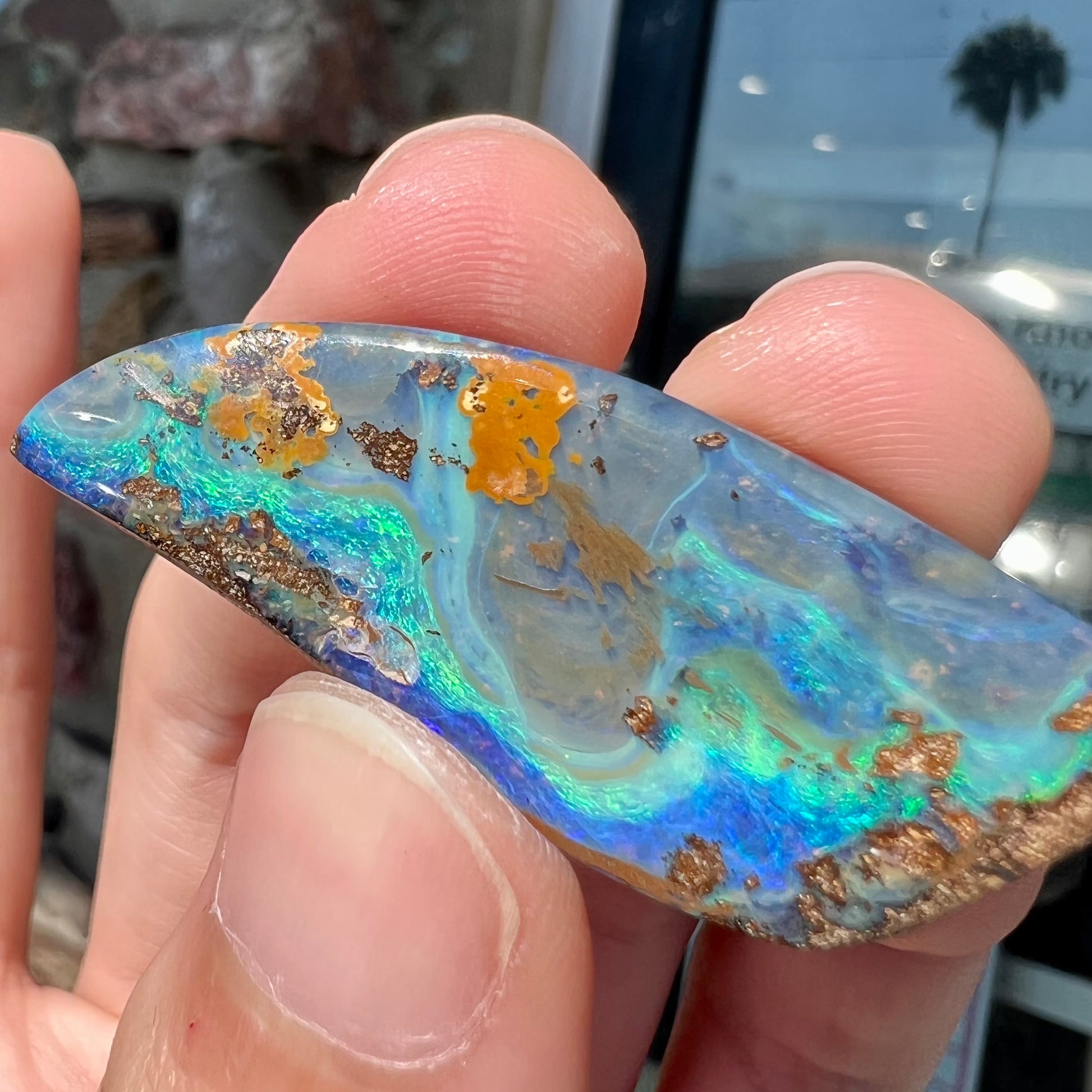 A freeform cut, loose black boulder opal stone from Queensland, Australia.