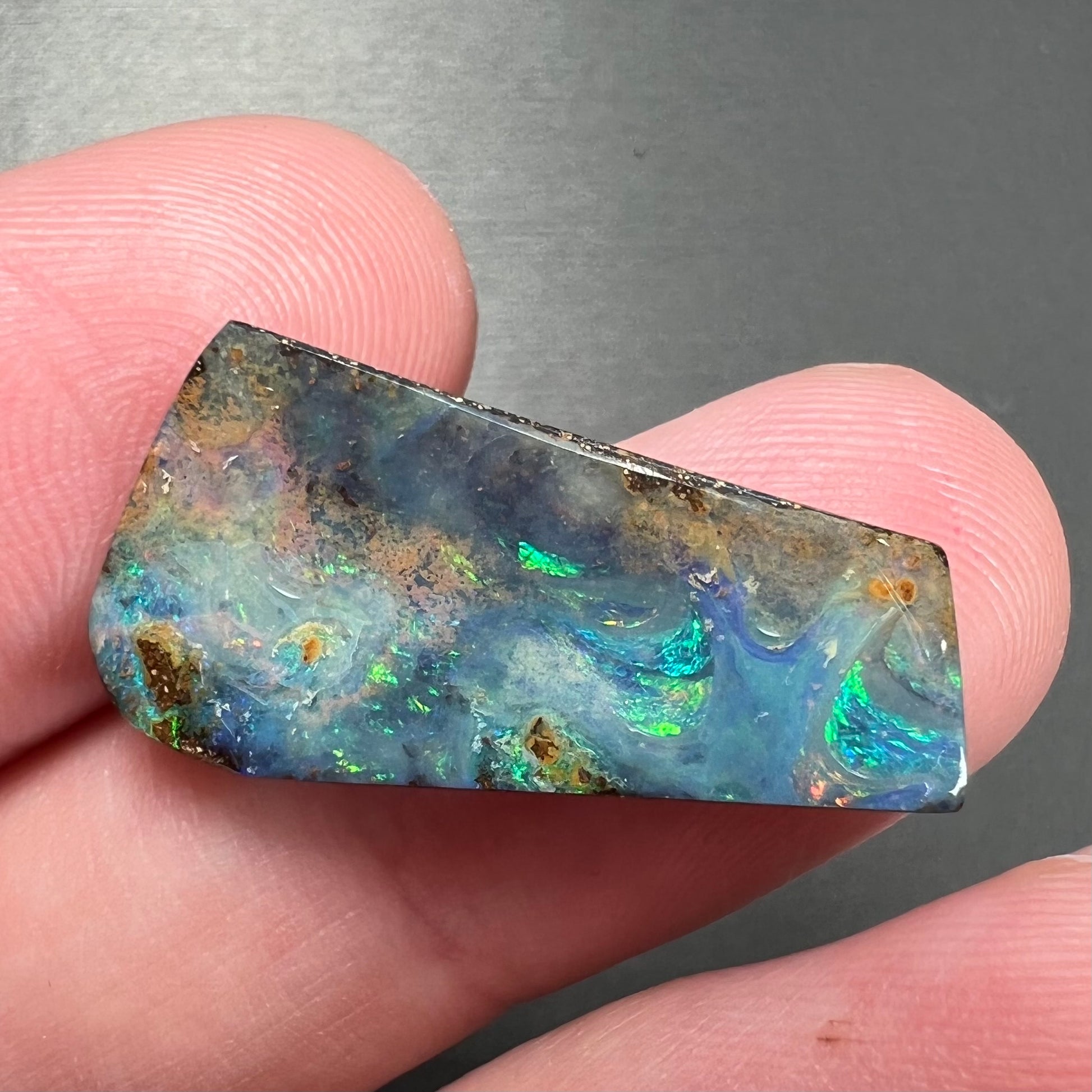 A loose, freeform cut boulder opal stone from Quilpie, Australia.