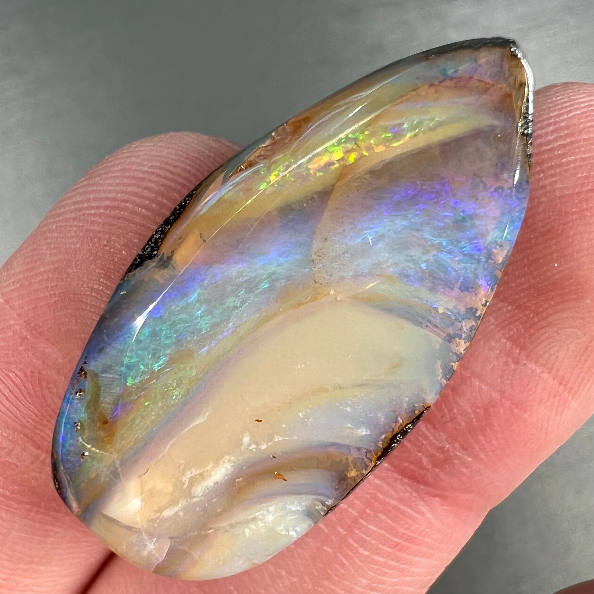 A loose, pear shaped cabochon cut boulder opal stone from Quilpie, Australia.