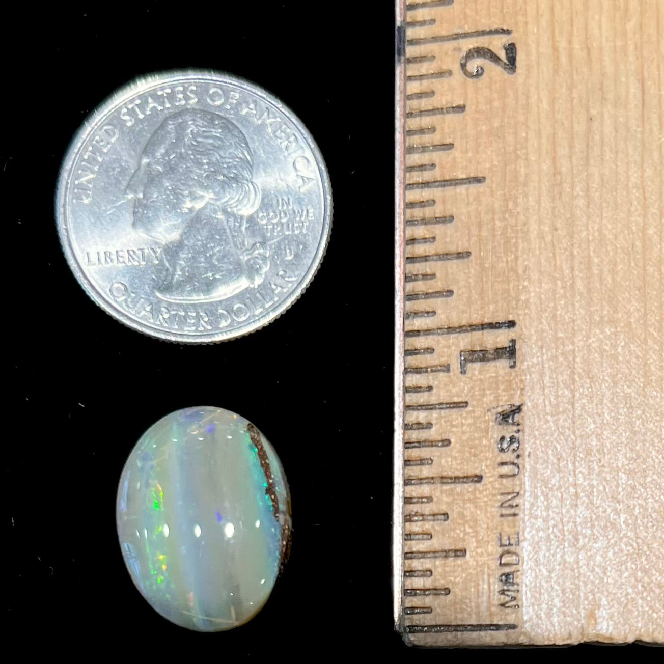 A loose, oval cabochon cut Quilpie boulder opal stone from Queensland, Australia.  The predominant color flash is green.