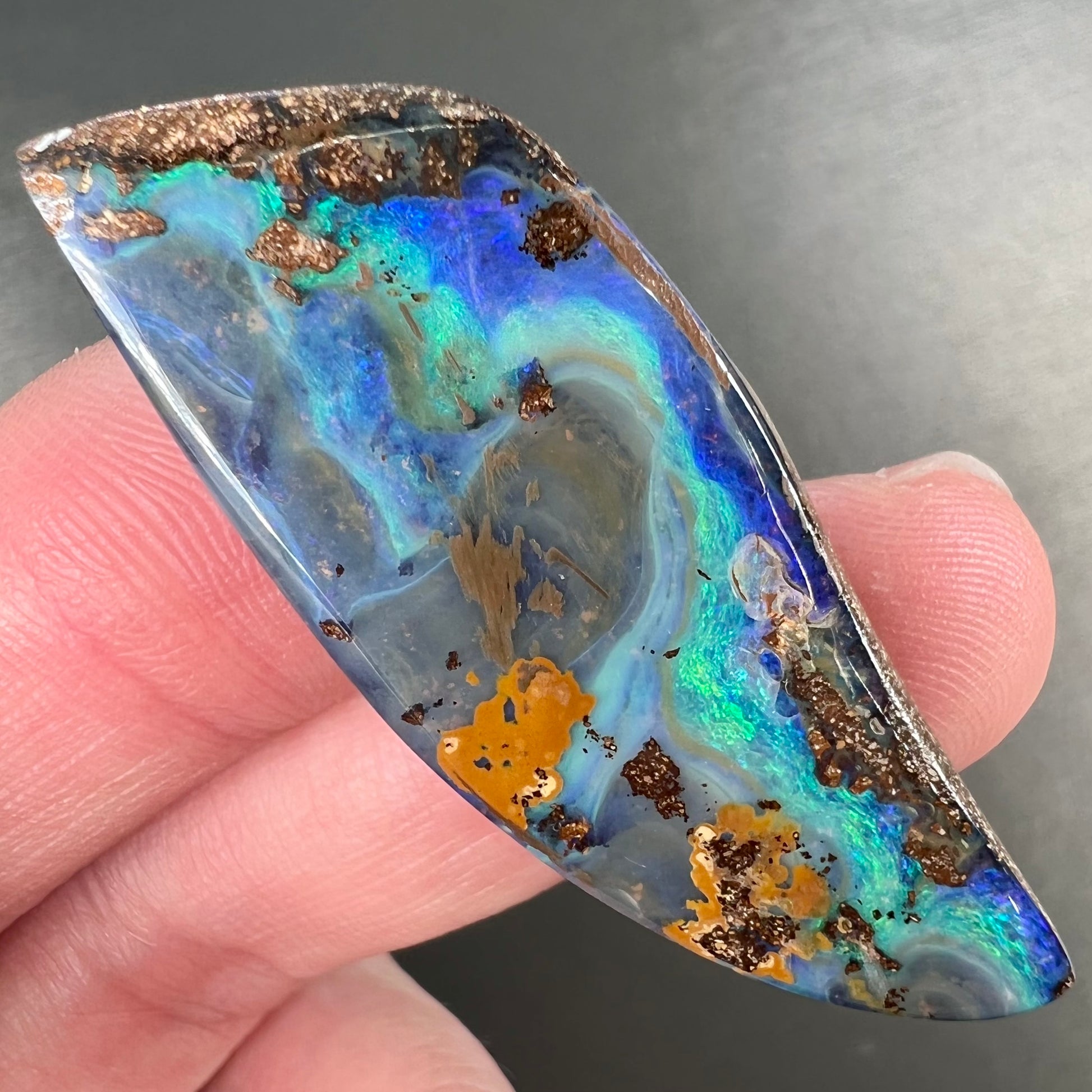 A freeform cut, loose black boulder opal stone from Queensland, Australia.