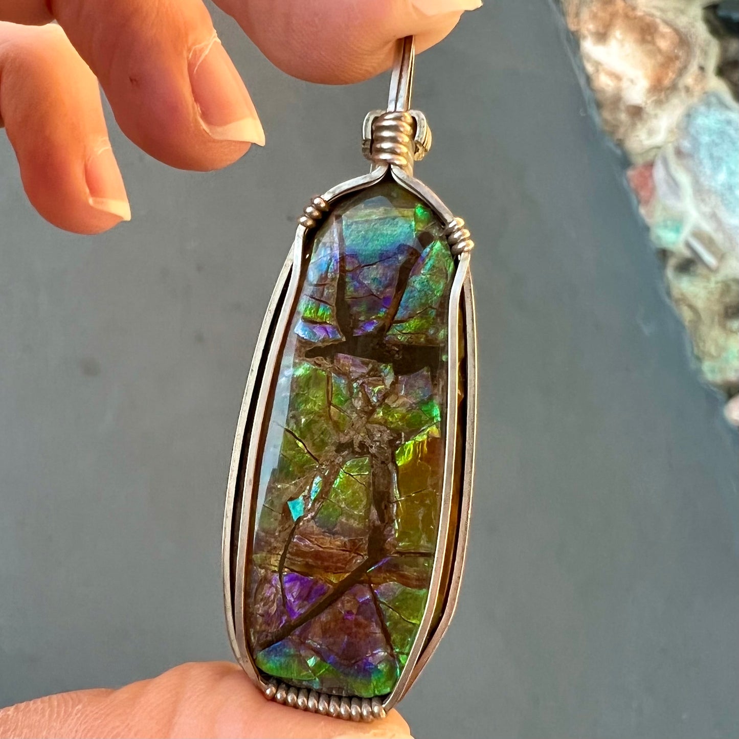 A sterling silver wire wrapped ammolite (gem quality rainbow ammonite) necklace.