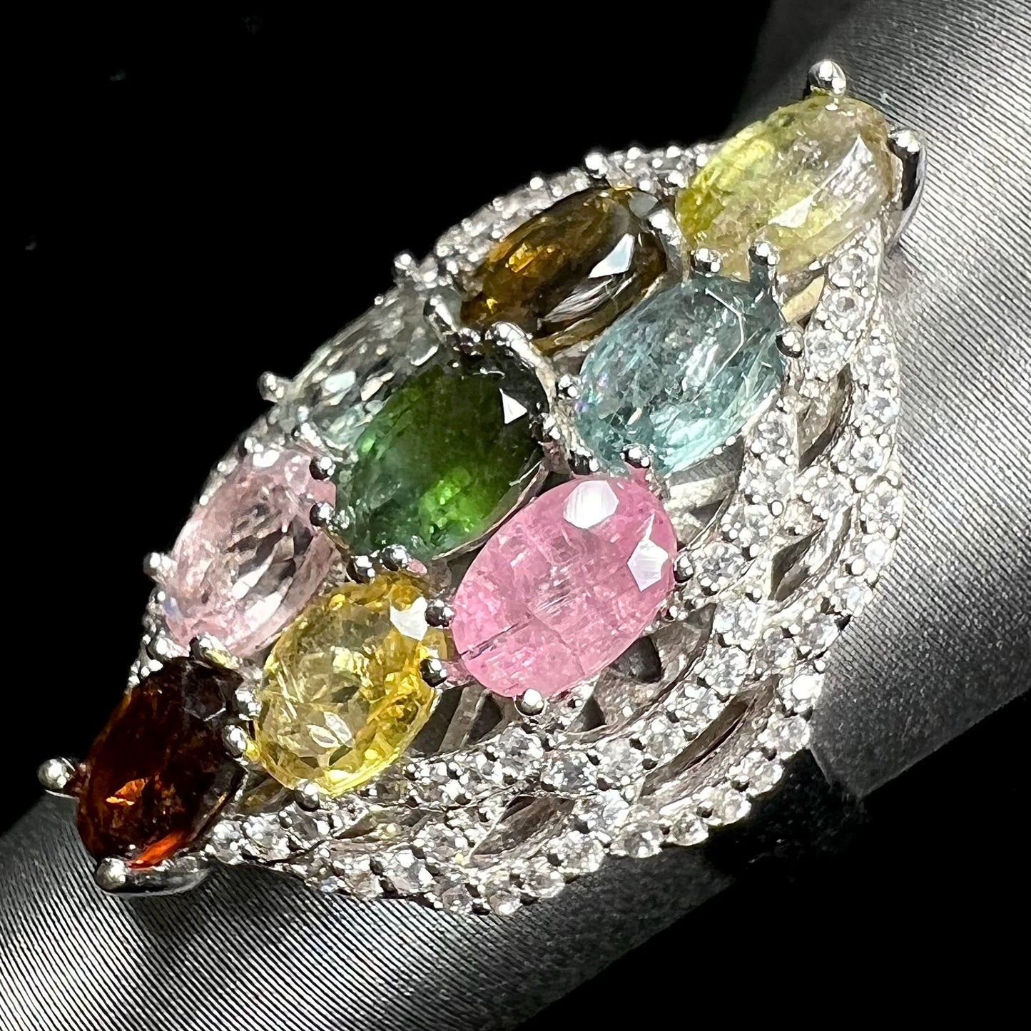 A silver gemstone cluster ring set with a rainbow of multicolored tourmaline stones.