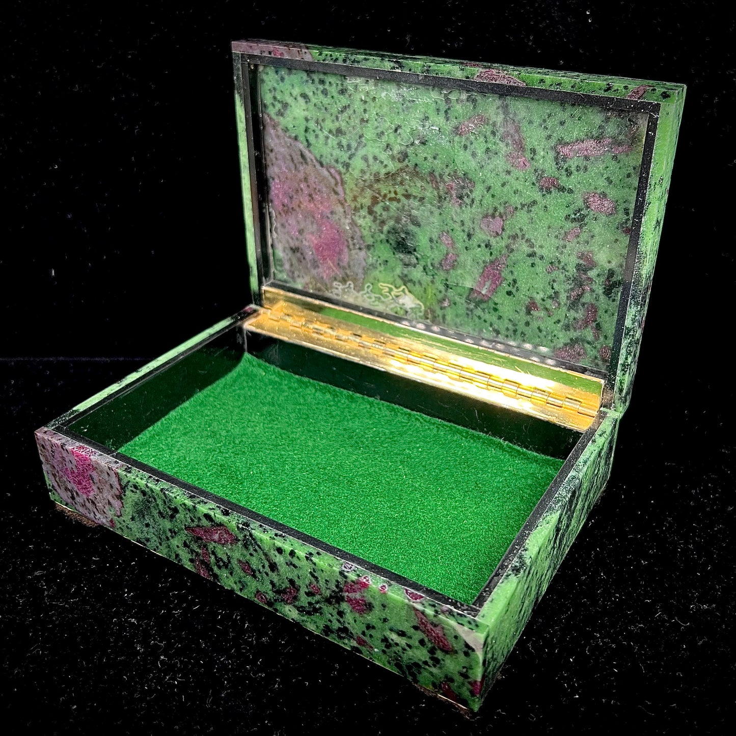 A stone box carved from Ruby in Zoisite stone and lined with green felt.