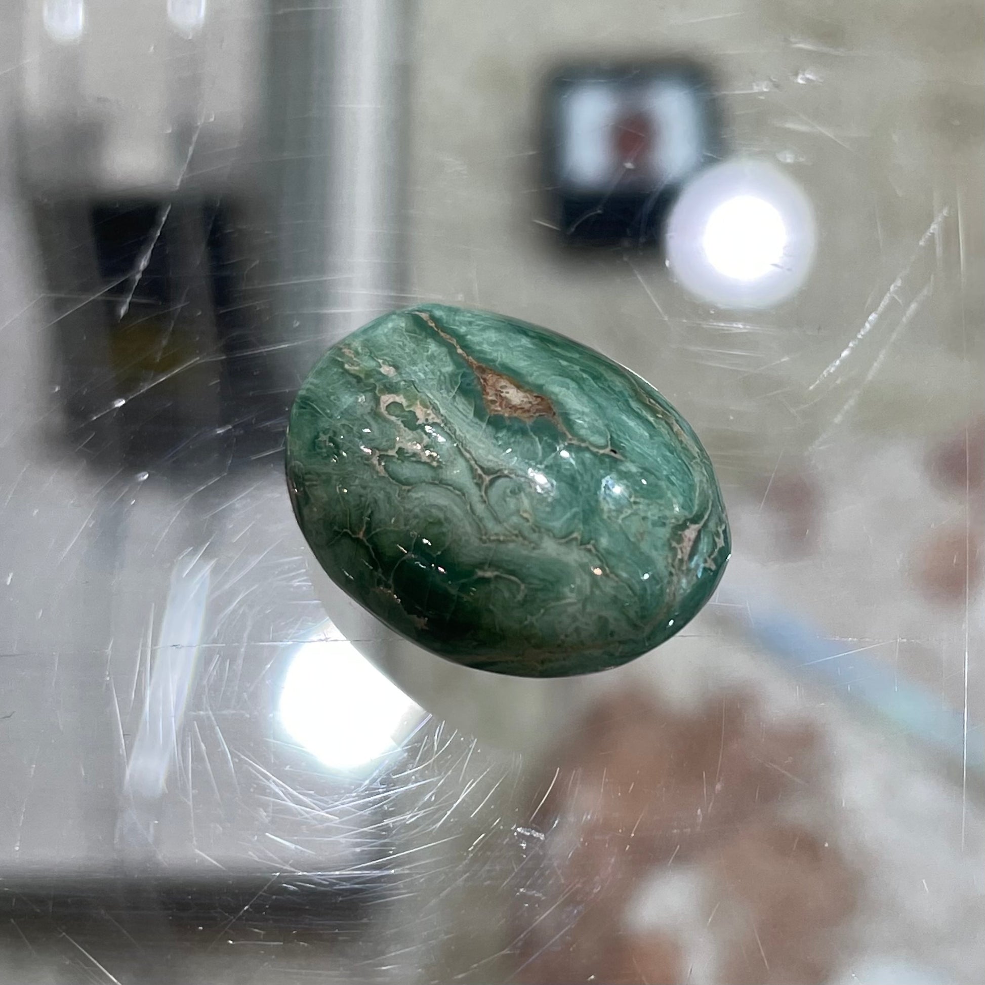 A loose, green oval cabochon cut turquoise stone from the Royston Mining District in Nevada.  Green color marbles around a light brown eye.