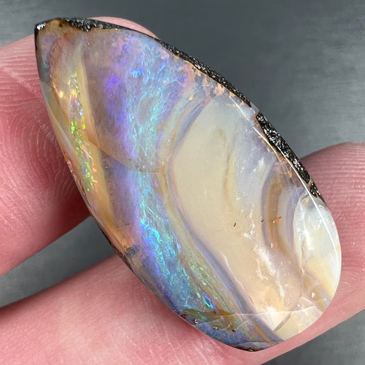 A loose, pear shaped cabochon cut boulder opal stone from Quilpie, Australia.