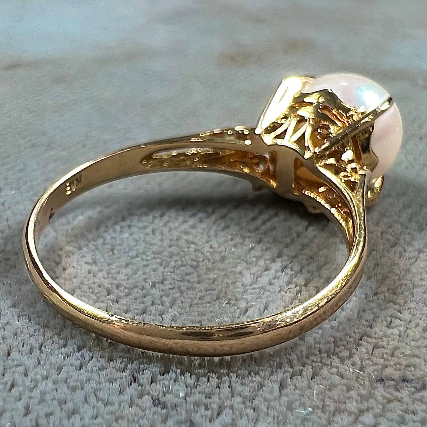 Round white pearl with pink overtones set in a vintage 18k yellow gold ring.