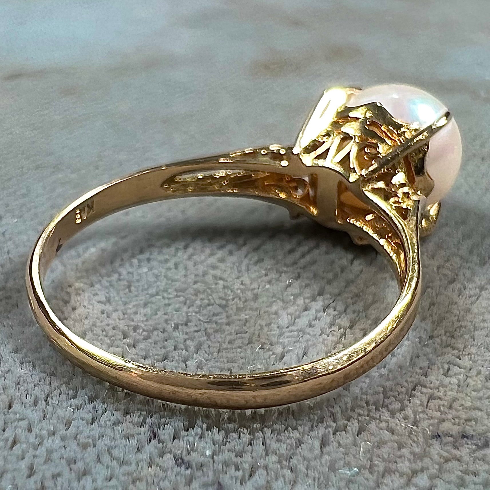 Round white pearl with pink overtones set in a vintage 18k yellow gold ring.