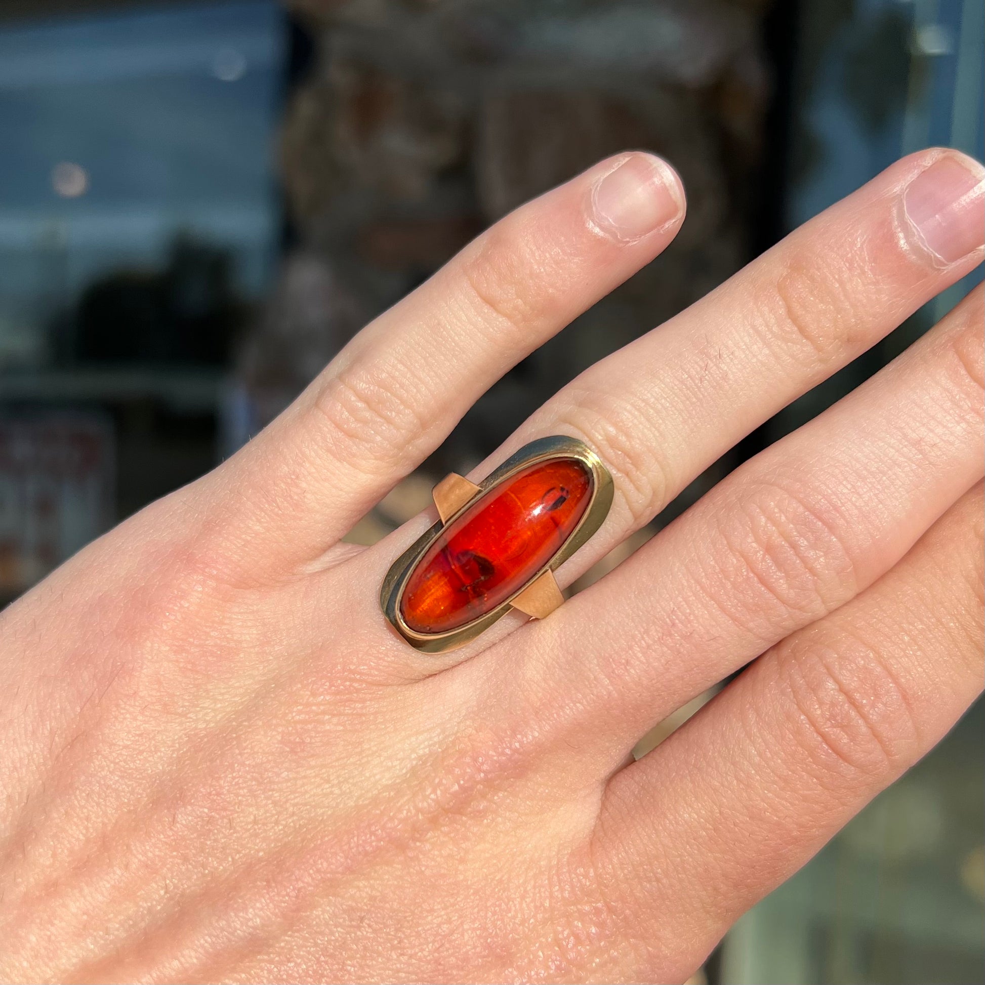 An oval cabochon cut Baltic amber stone set in a yellow gold ring and stamped "AMBER GUILD."