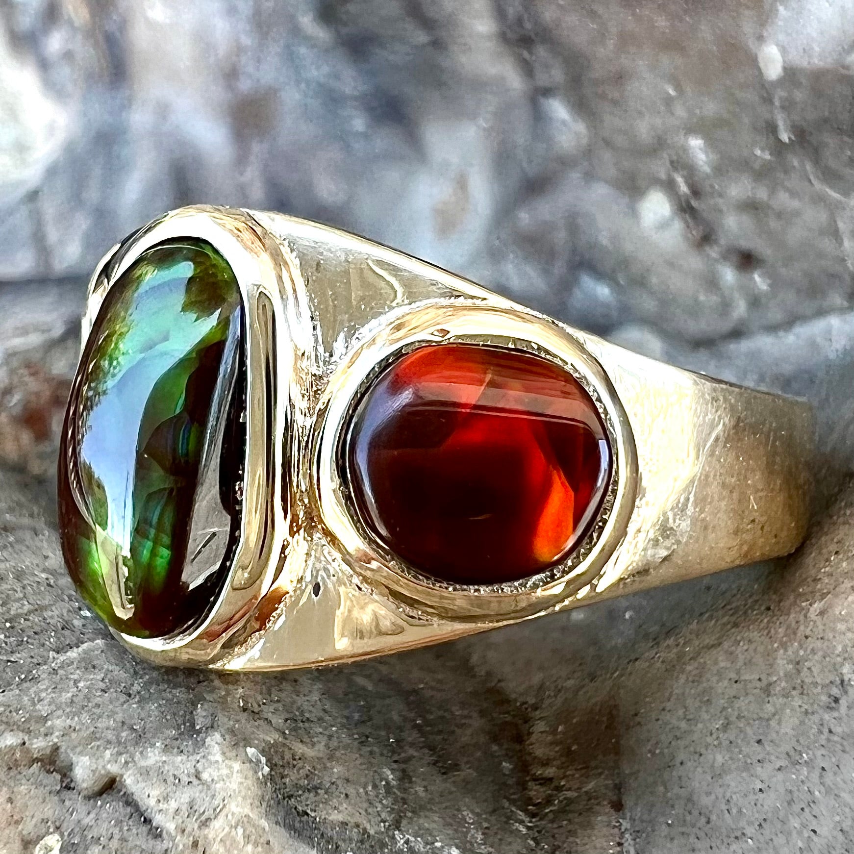 A ladies' yellow gold ring set with two fire agate stones: one green, and one red.