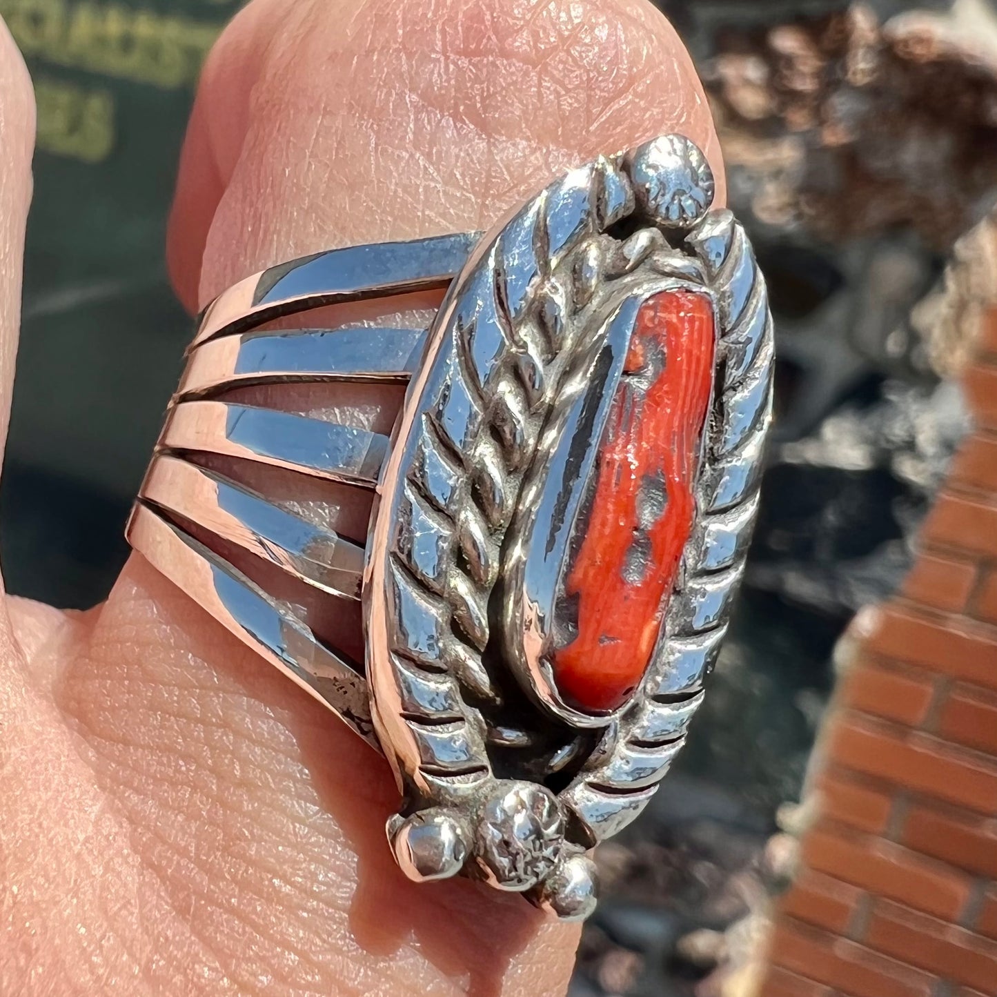 A sterling silver ring set with a polished red coral branch handmade by Navajo artist, Delbert Chatter.