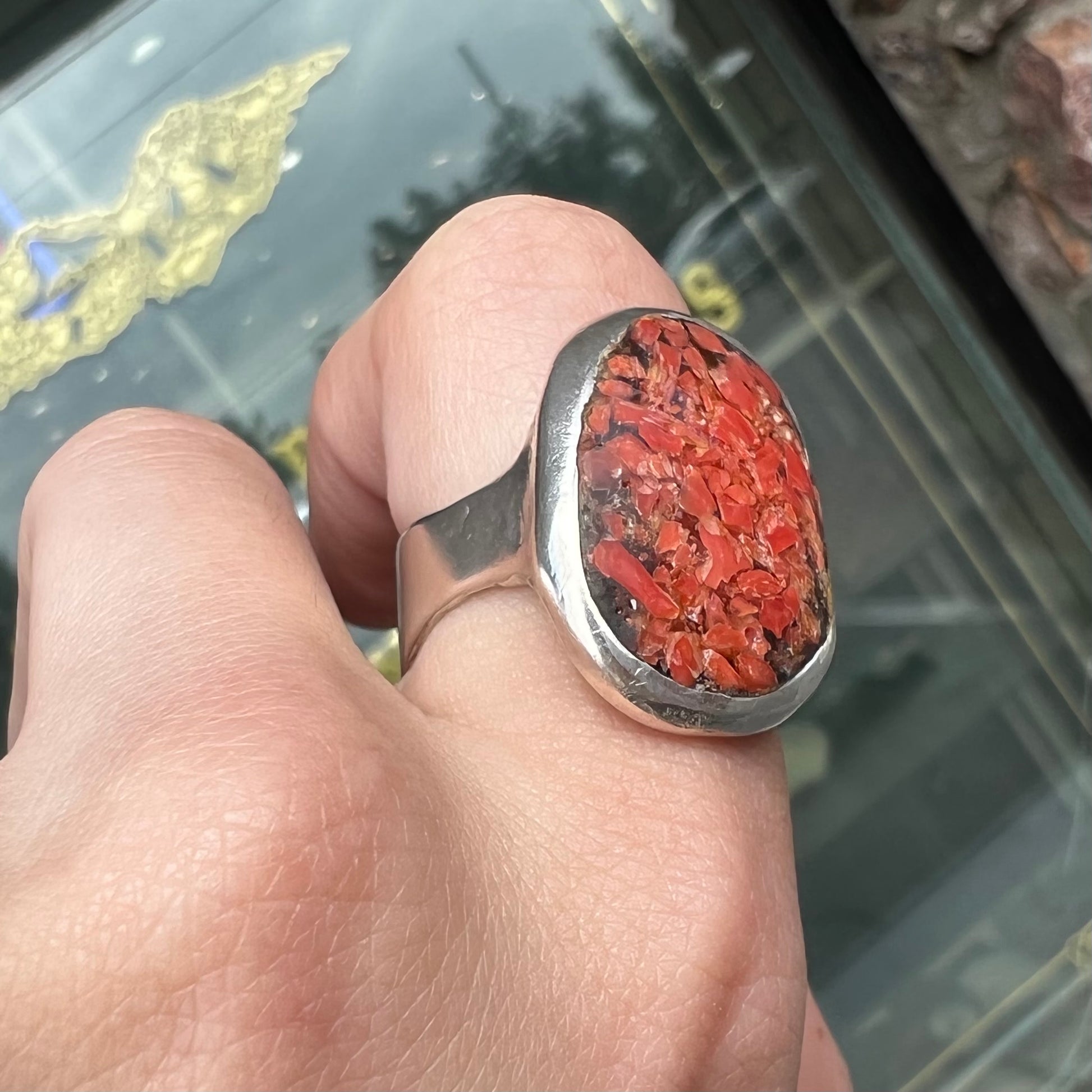 A rustic style, handmade silver men's ring set with crushed red coral.