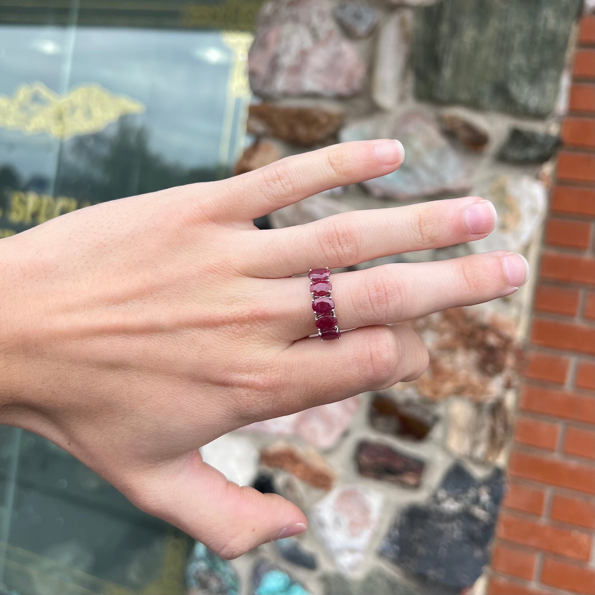 A sterling silver, five stone, faceted oval cut red ruby stackable ring.