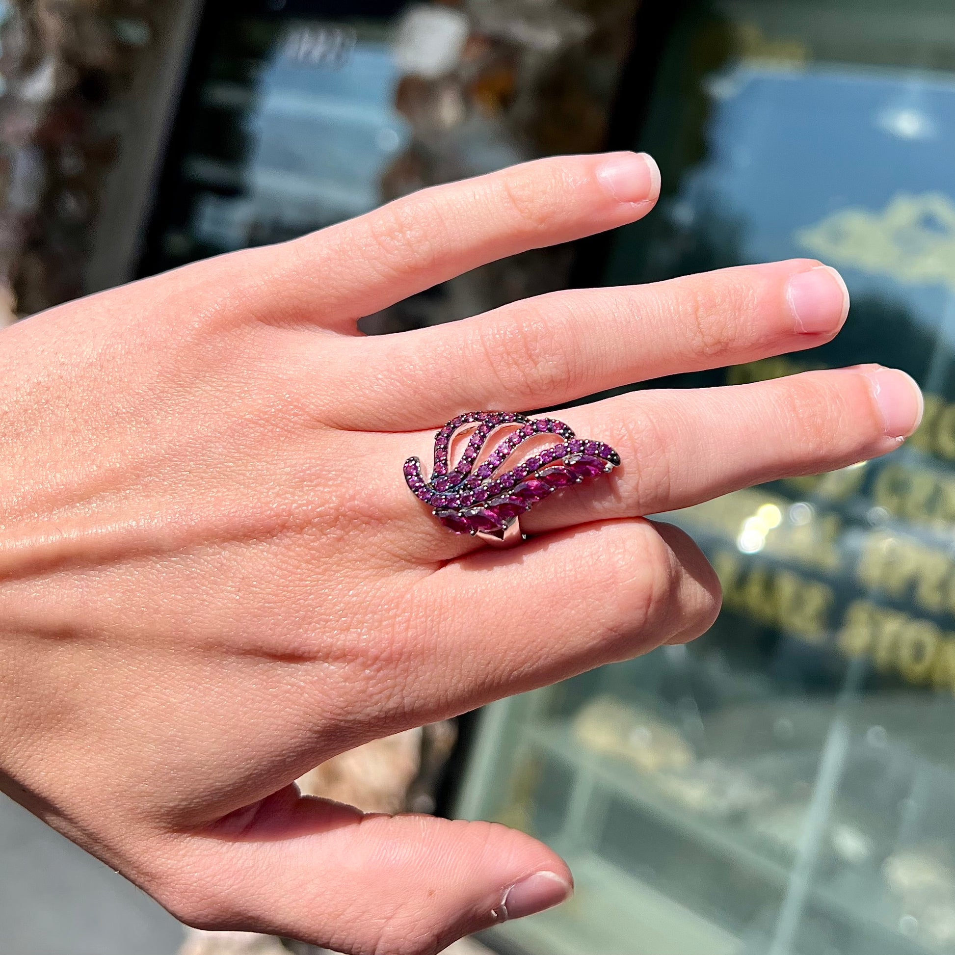 A sterling silver, feather shaped ring set with round and marquise cut rhodolite garnet stones.